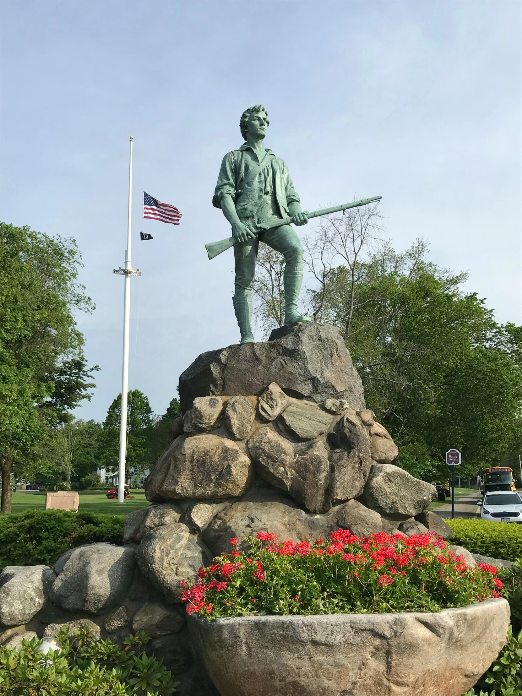 the statue of a man is holding a rifle on a rock