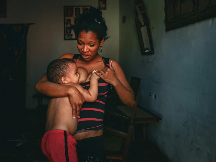 woman holding child with arm wrapped around another