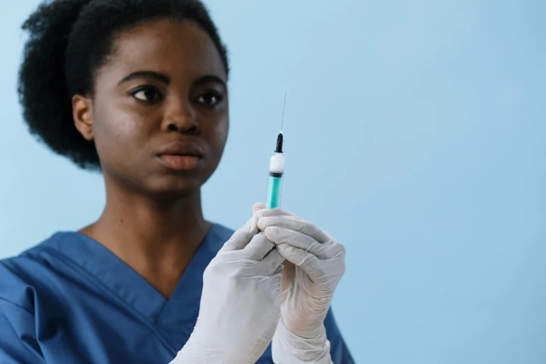 a nurse holding a needle up to the needle