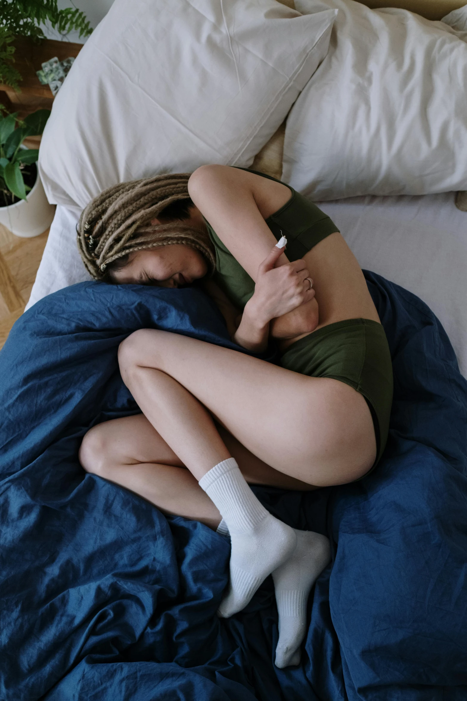 a woman that is laying on a bed with her arm under the pillow