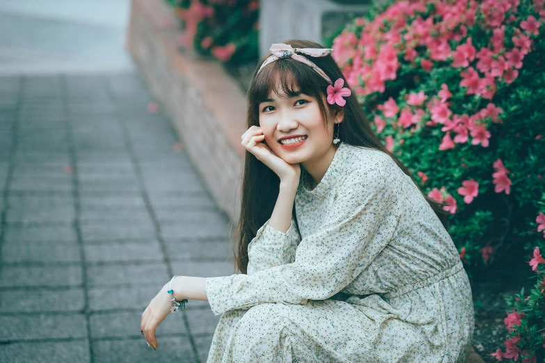 the woman is sitting down by a plant with flowers