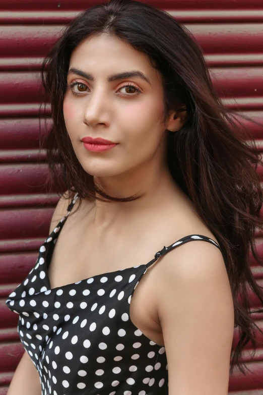 a young woman posing for a po in front of a metal garage door