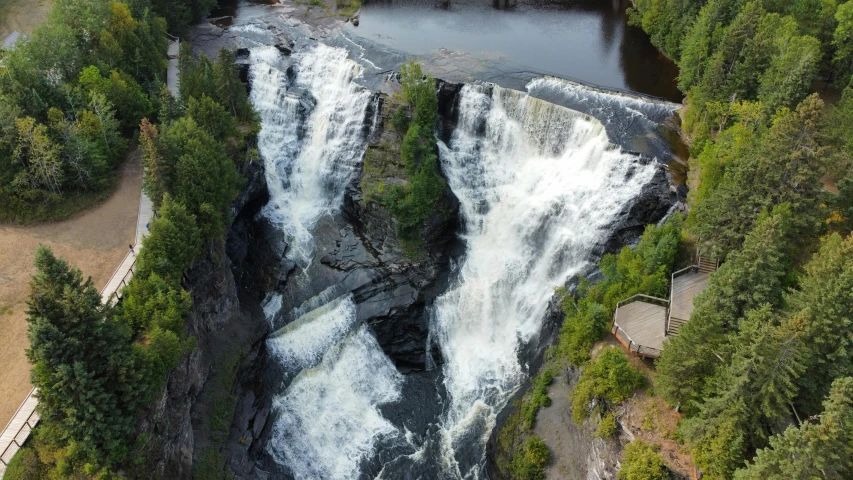 a waterfall flowing in a lake next to forest