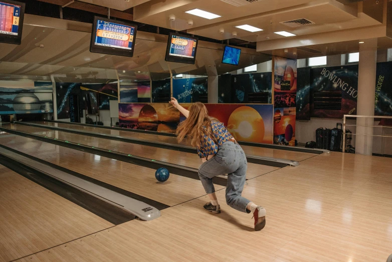 a woman who is on her knees at the bowling alley