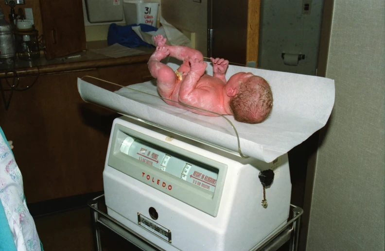 a newborn baby is laying on top of a scale