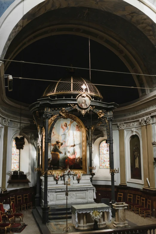 a small altar in an old church has artwork hanging on it