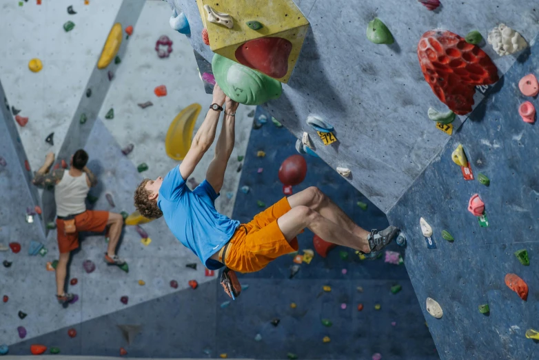 a man doing a boulder climbing trick in a rock - climbing competition