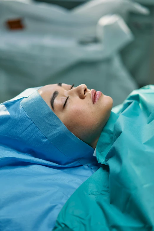 a woman in scrubs sleeping on a hospital bed