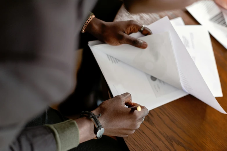 some people are holding papers at a table