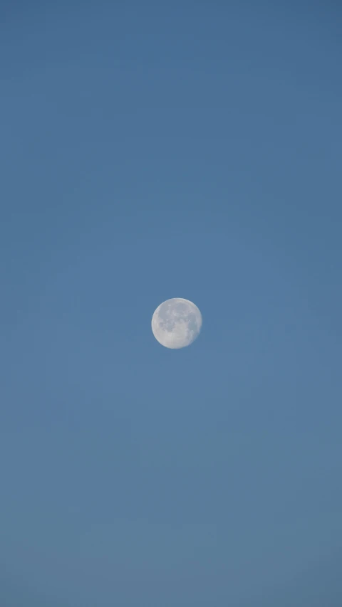 there is a half - moon in the blue sky