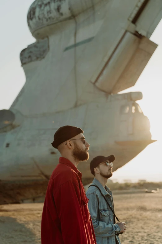 two men look out at an aircraft sitting on the tarmac