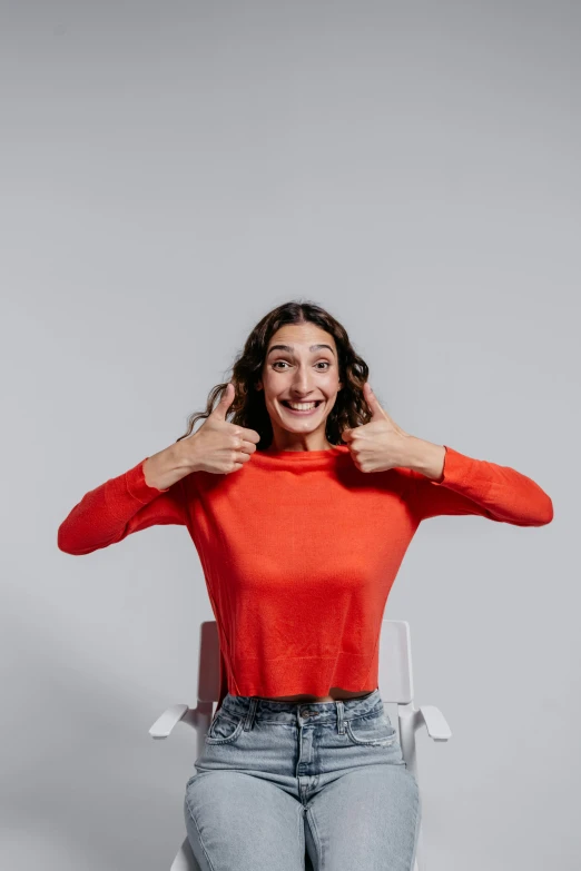 woman with a large toothy smile holding her hands on her shoulders