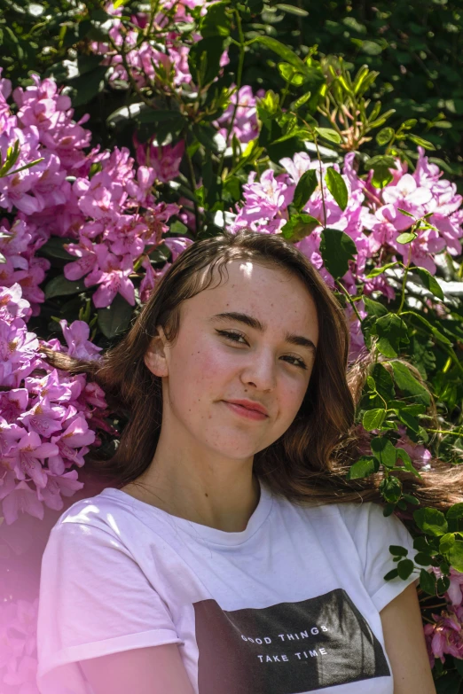 a young woman posing under a tree filled with flowers