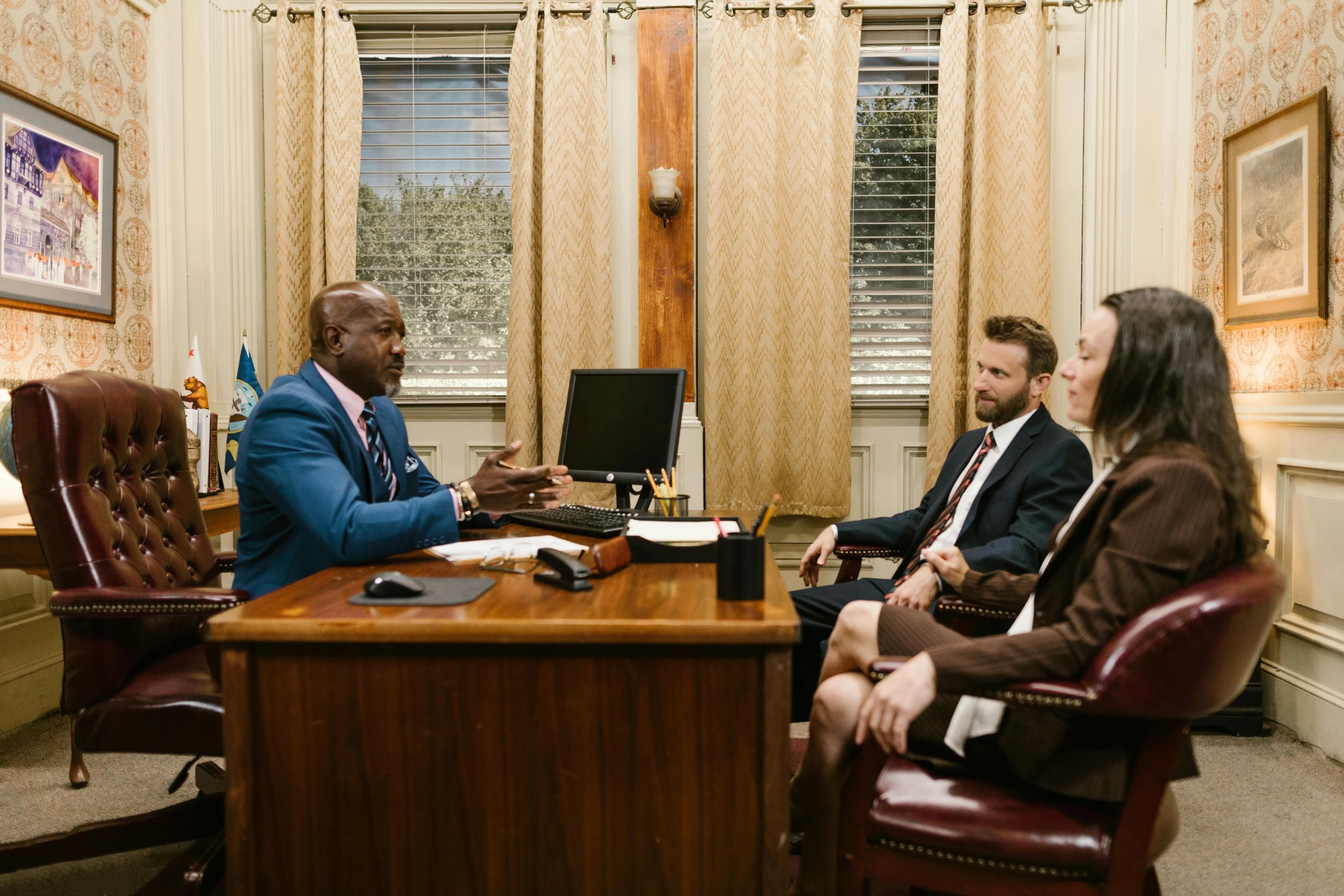 three business people are sitting at a table and talking