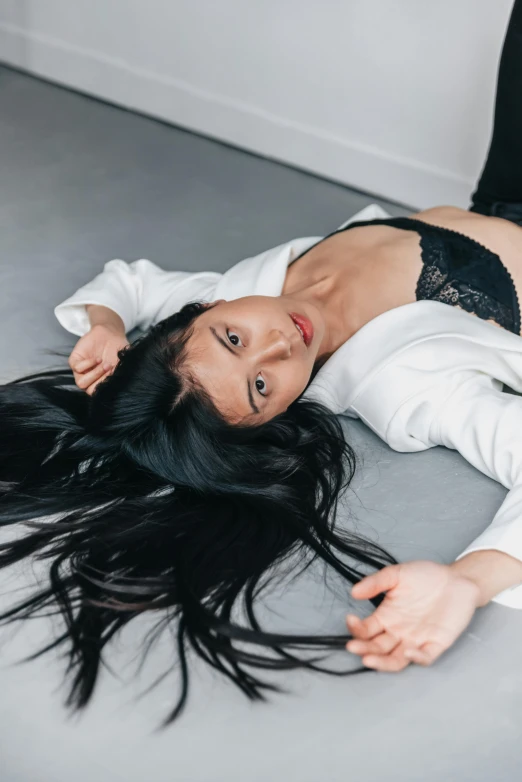 the woman is posing on the floor with her hair in the air