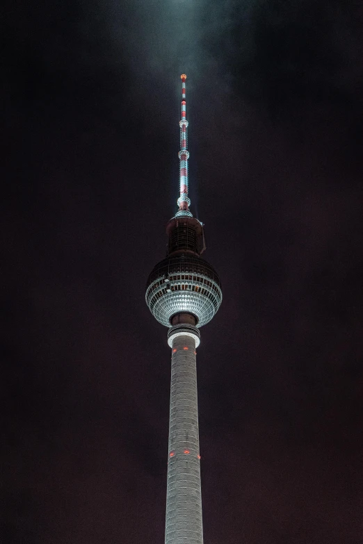 a tower with lights that are lit up in the night sky
