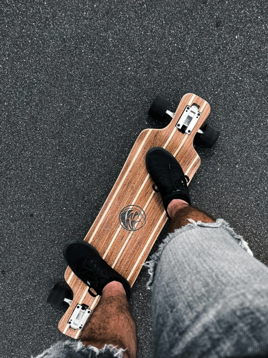 a person standing on the ground holding on to a skate board