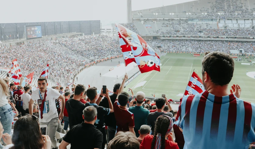 a football stadium with many people holding flag flags