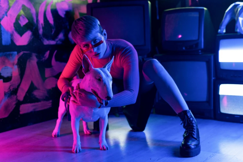 a woman sitting on the floor petting a small dog