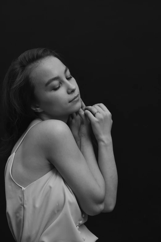 a black and white image of a woman touching her face