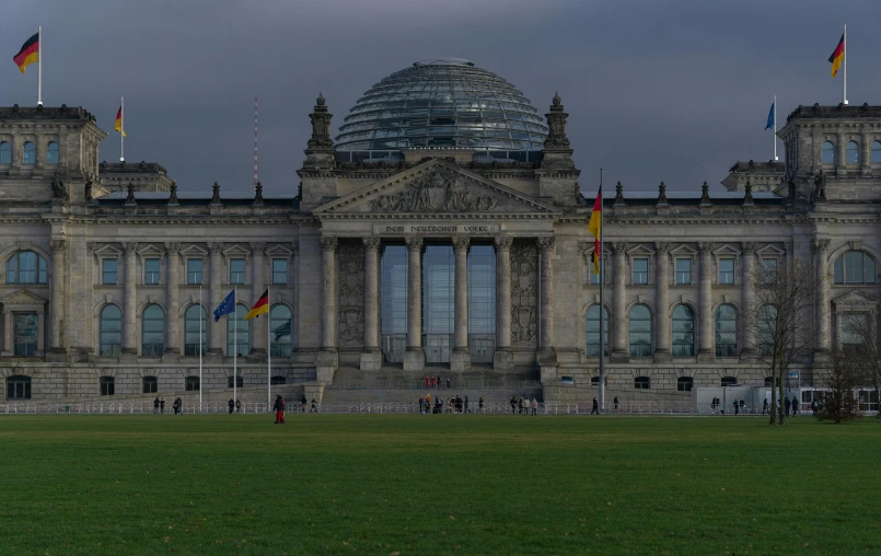 a group of flags in front of a large building