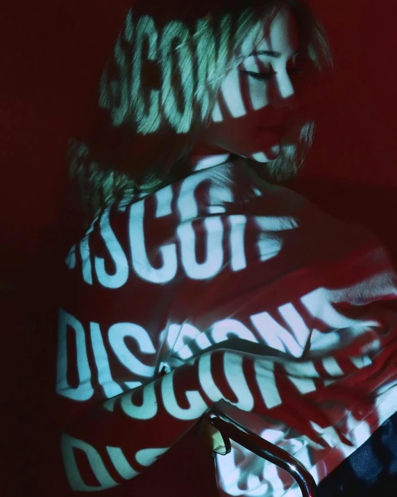 a woman wearing a red and white shirt with the words disconous projected across her