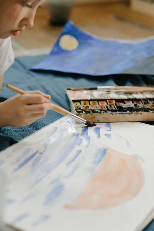 a young man holding a painting brush in his hands