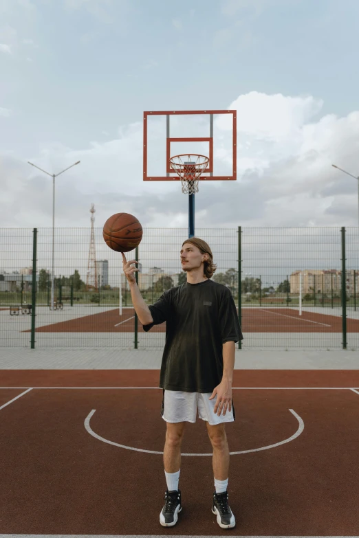 a man in black shirt and shorts holding up a basketball