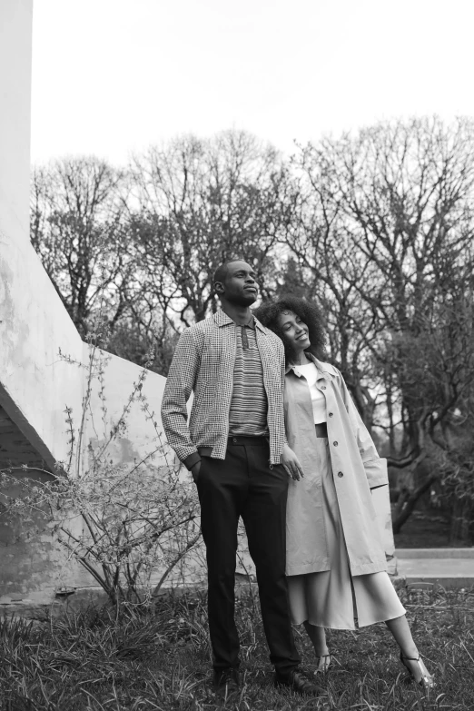 a man and a woman standing on the grass