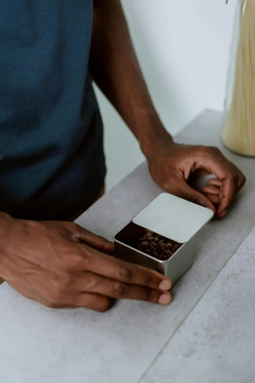 a person holding a square box with some food inside of it