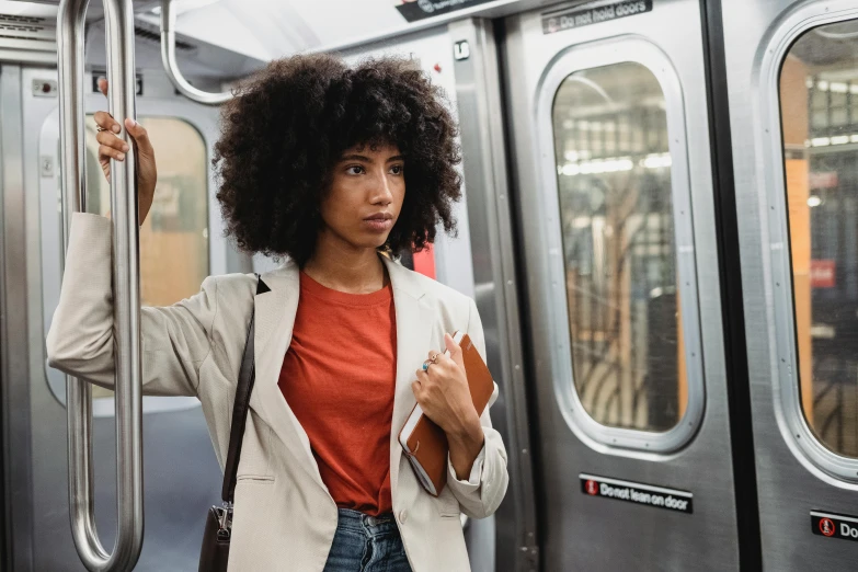 a woman stands next to the doors of a subway car