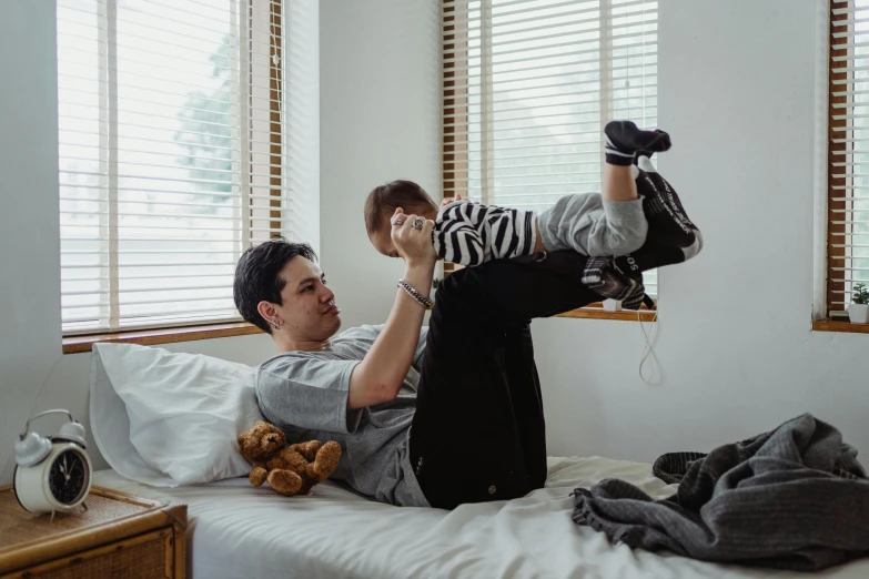 a man laying on top of a bed holding a 