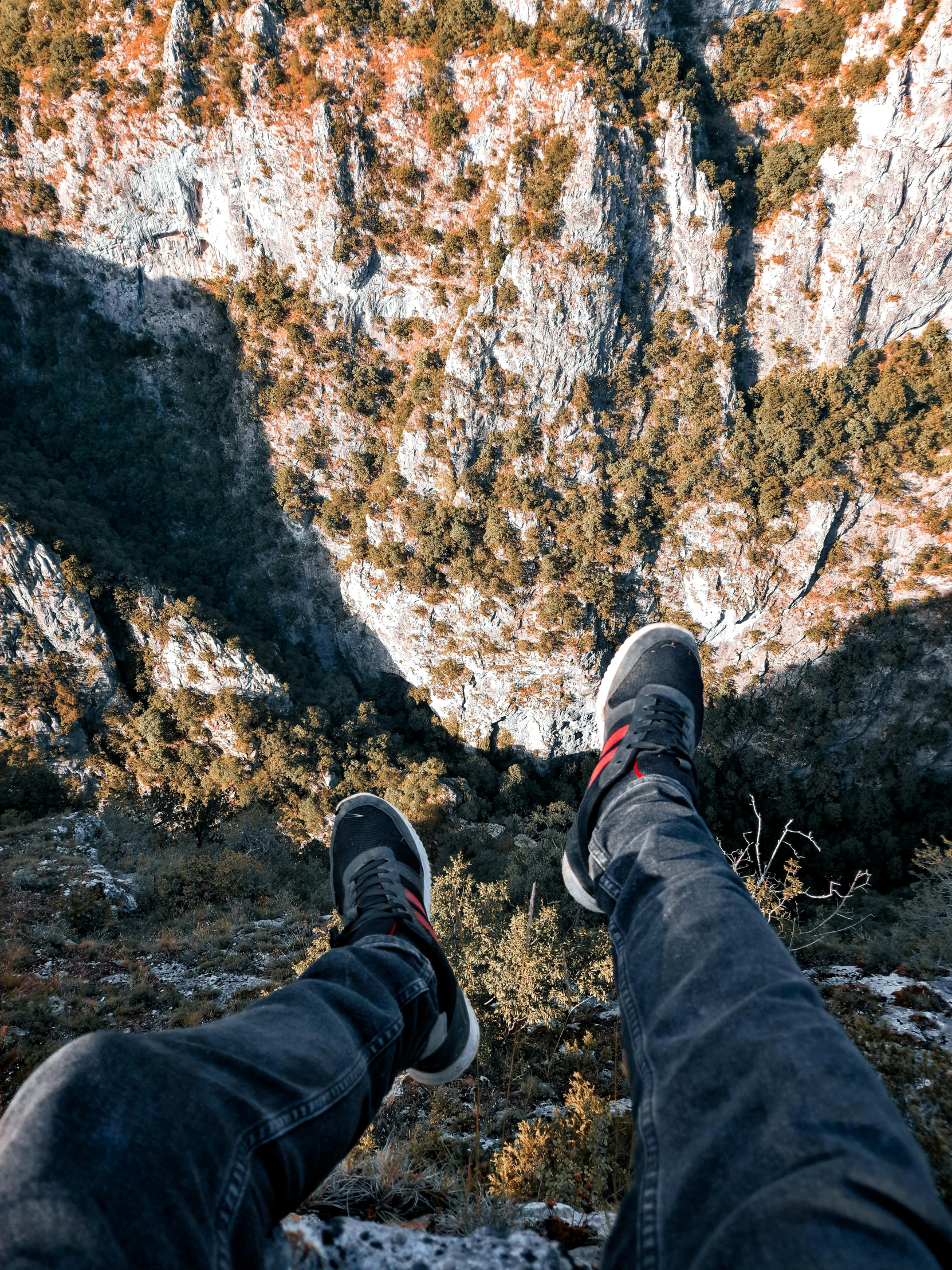 person standing near the top of a steep mountain looking down