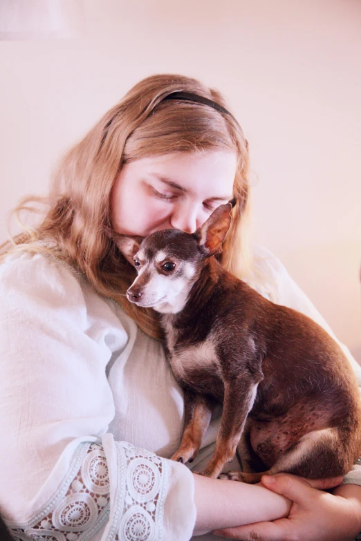 the woman is holding her small dog inside