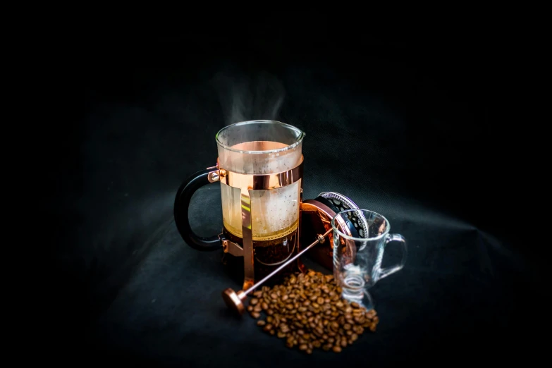 some coffee beans and a mug that is on the ground