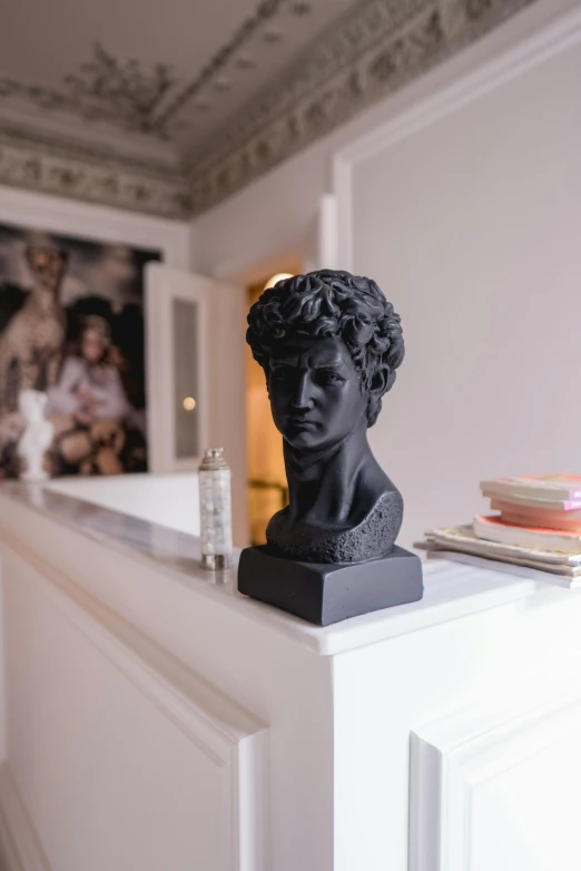 a sculpture of a head on a dresser is seen