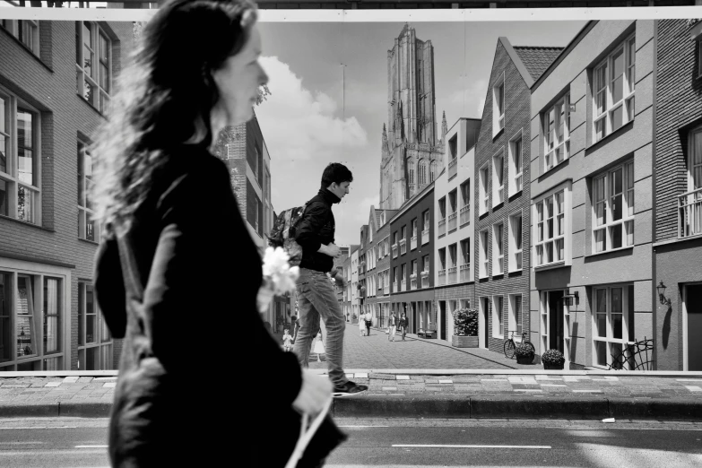 black and white pograph of people walking in front of apartment buildings