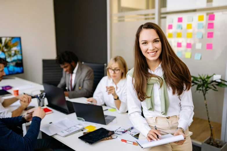 the woman smiles while standing next to some other people