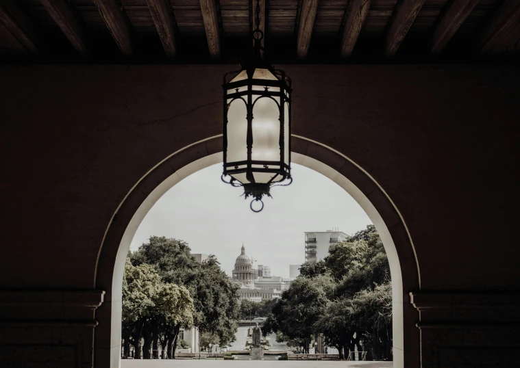 an archway that leads to a park with trees around it