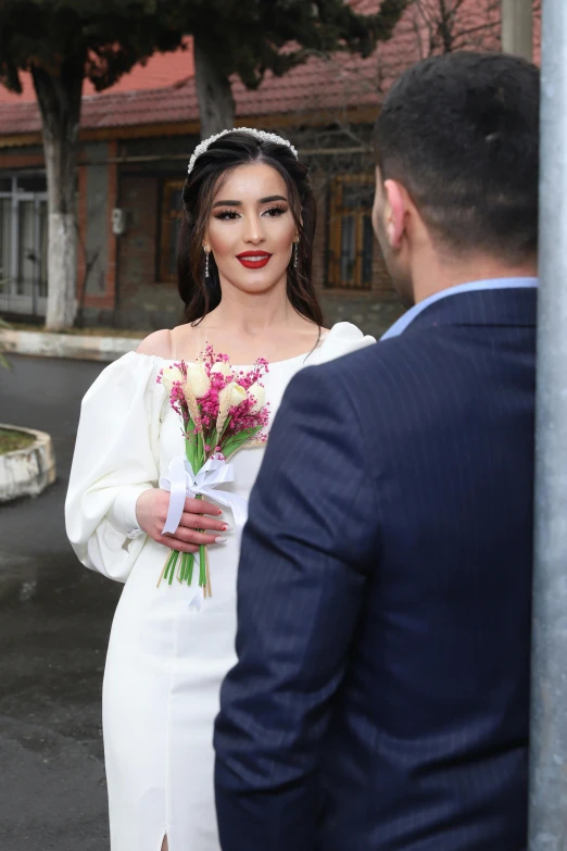 a man in a suit talking to a woman in a white dress