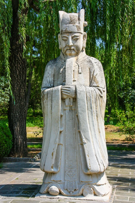 an old statue with a big head and an umbrella hanging from it