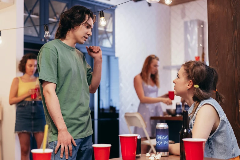 the young couple is sitting at the table having drinks