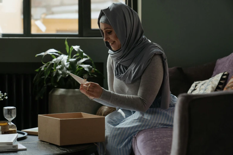 a woman looking at her phone while sitting in a chair