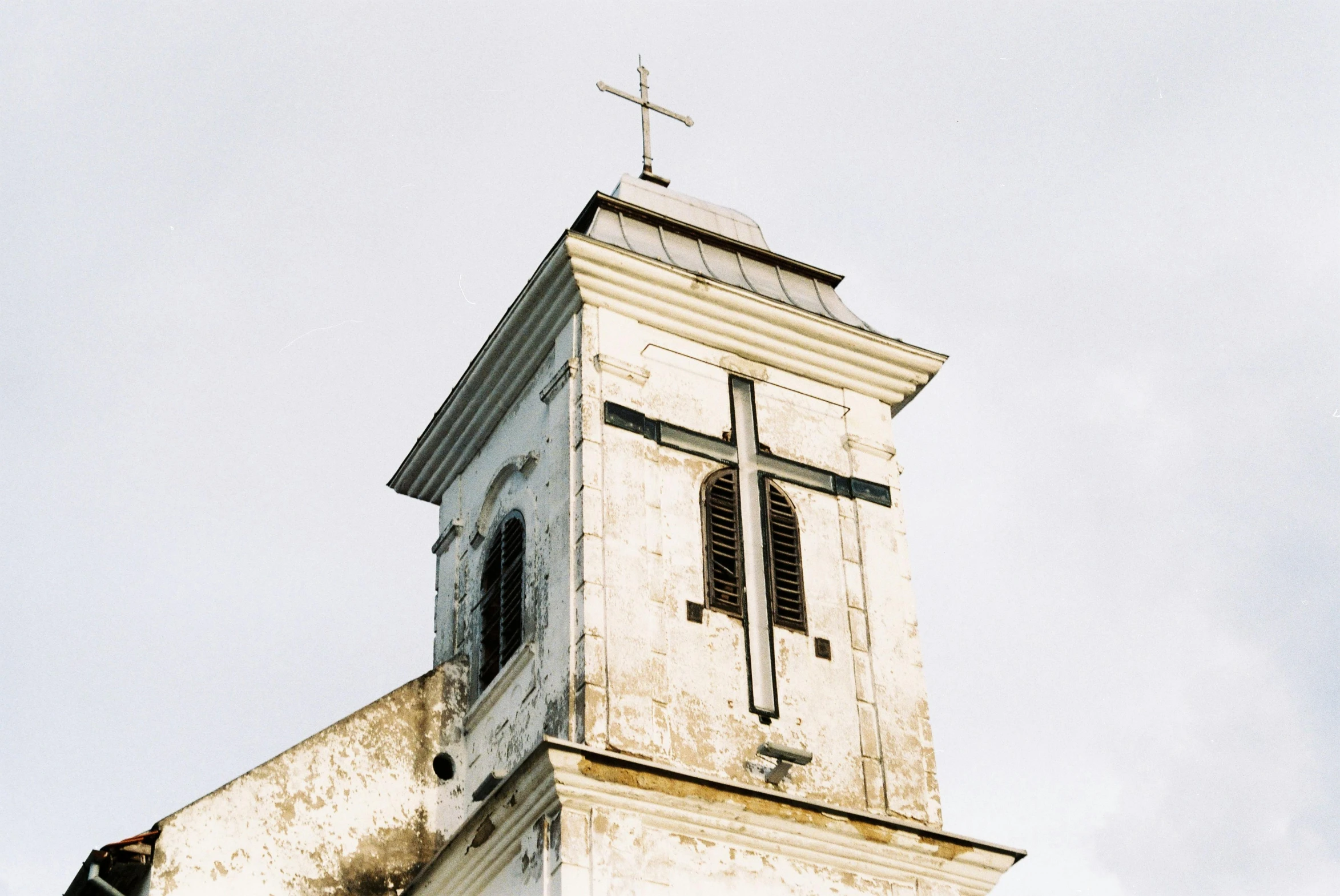 a tall white steeple with a cross at the top
