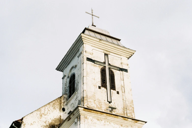 a tall white steeple with a cross at the top