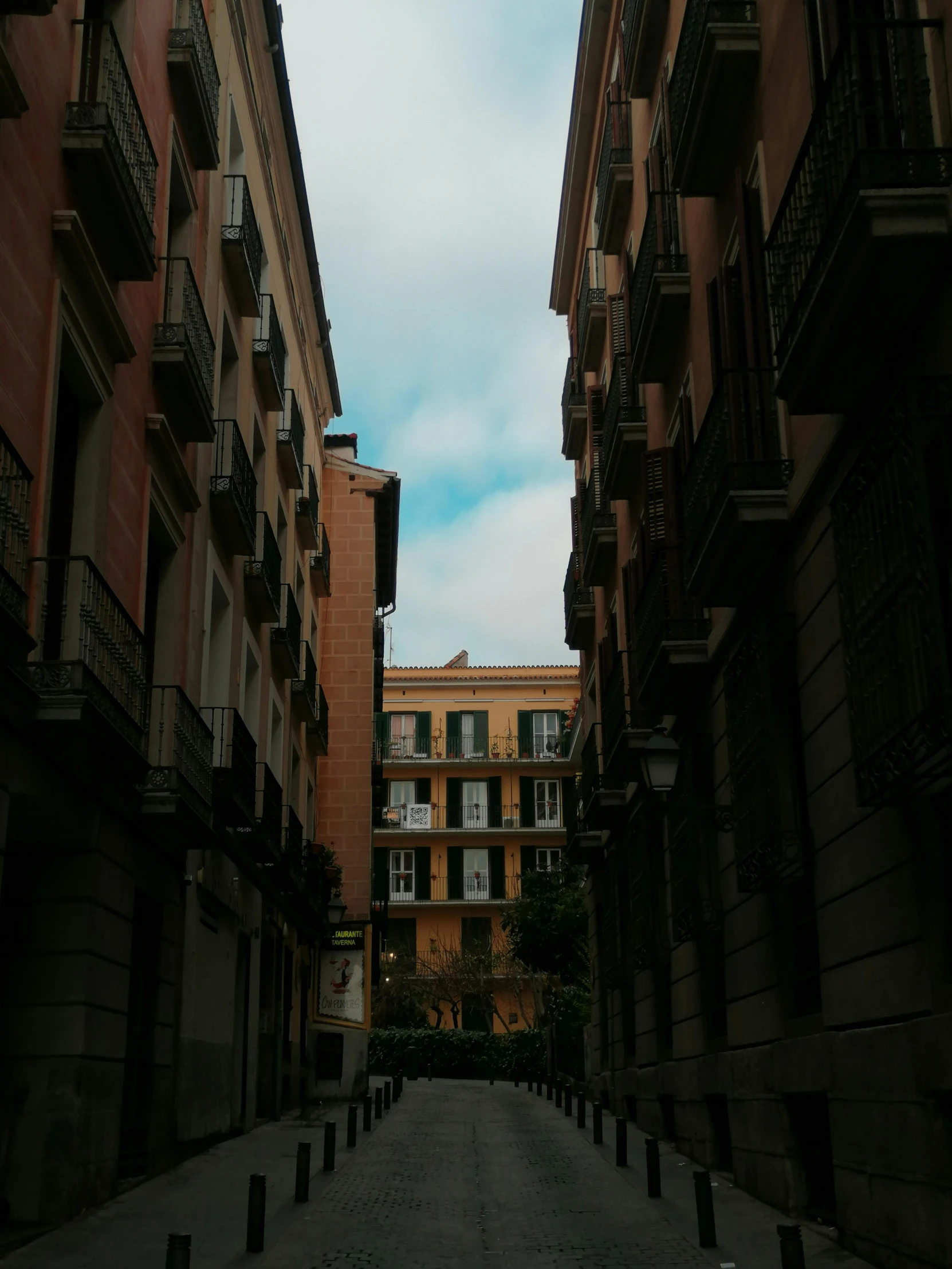 an empty street with buildings and lights on the building