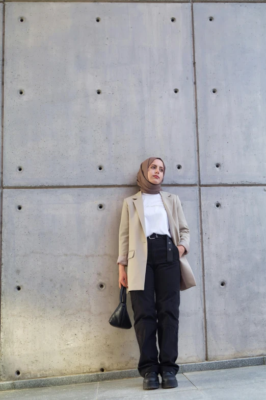 woman standing near large gray wall with black boots