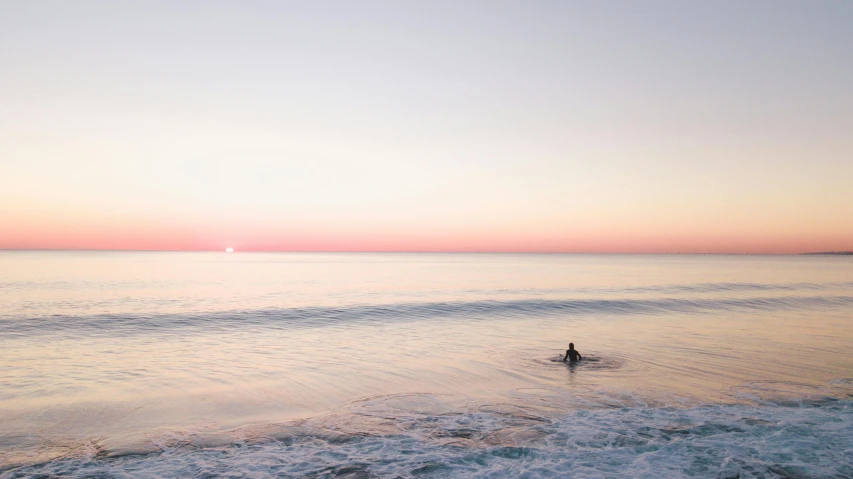 a person is in the ocean with a surfboard