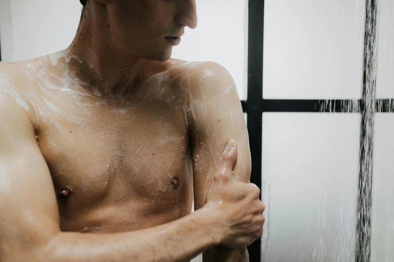 a man washing his hands in the shower