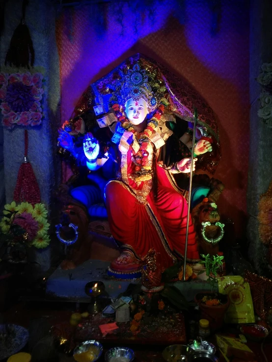 statue in doorway of illuminated display surrounded by bowls